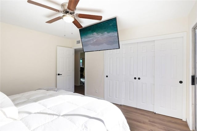 bedroom with a closet, visible vents, ceiling fan, and wood finished floors