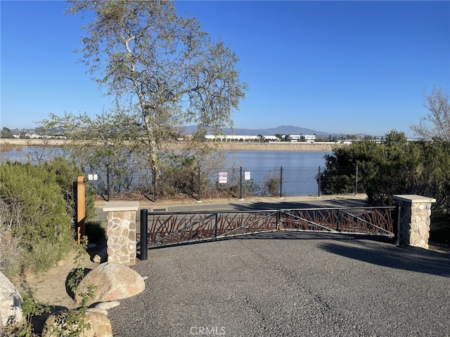 view of gate with a water and mountain view