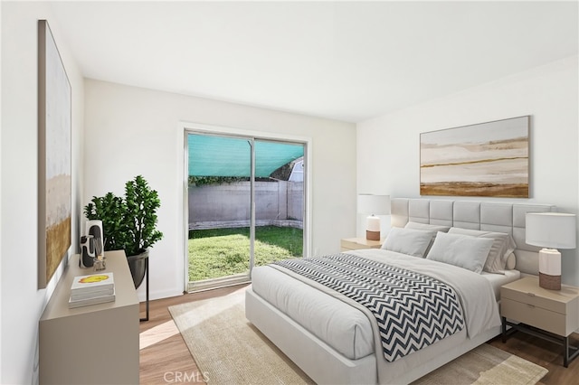 bedroom with access to outside and wood finished floors