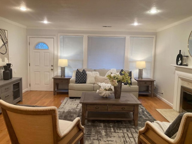 living room with crown molding, a high end fireplace, and light hardwood / wood-style flooring