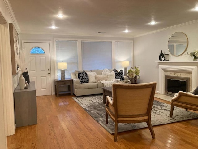 living room with ornamental molding, a high end fireplace, and hardwood / wood-style floors