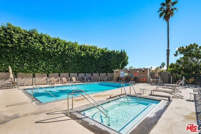 view of pool featuring a hot tub and a patio area