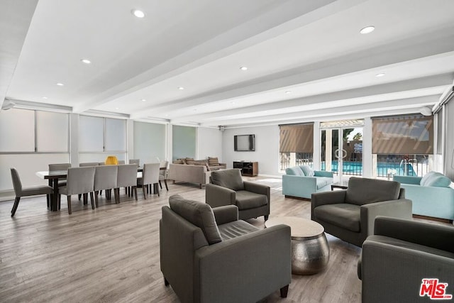 living room featuring beam ceiling and light hardwood / wood-style floors