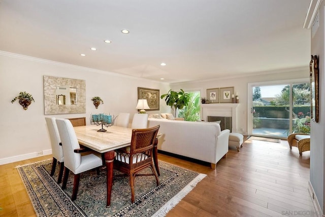 dining area with hardwood / wood-style floors and crown molding