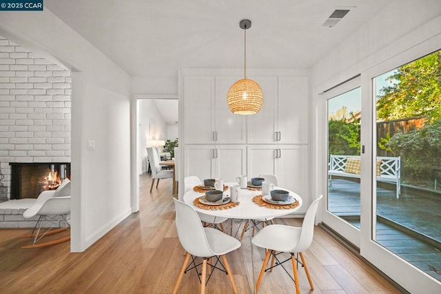 dining area featuring a fireplace and light hardwood / wood-style floors