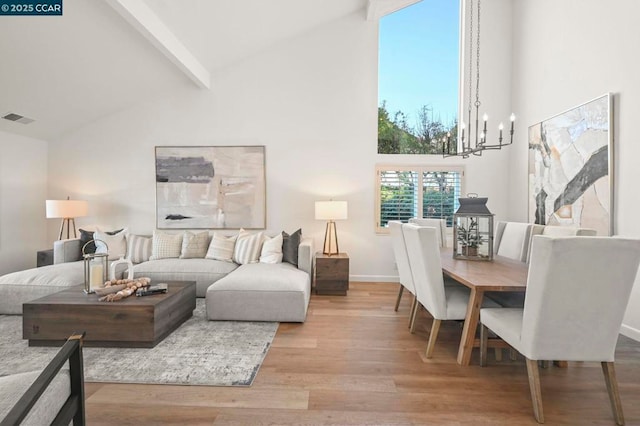 living room featuring beamed ceiling, light wood-type flooring, high vaulted ceiling, and a notable chandelier