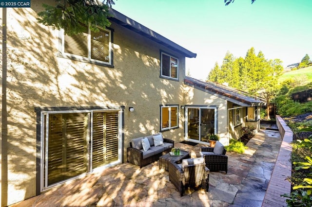 back of property featuring an outdoor living space and a patio