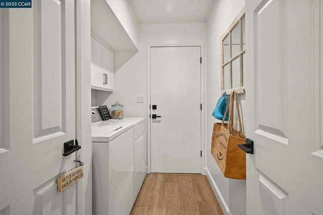 washroom with independent washer and dryer, cabinets, and light hardwood / wood-style flooring