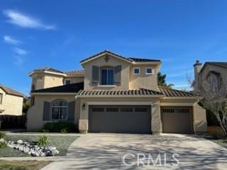 mediterranean / spanish house with a garage