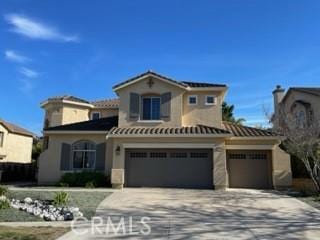 mediterranean / spanish home with concrete driveway, stucco siding, and a garage