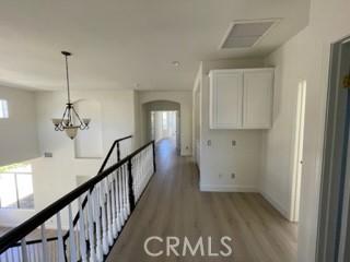 hall featuring hardwood / wood-style floors and an inviting chandelier