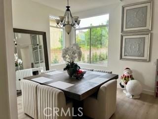 dining space with an inviting chandelier and light wood-type flooring