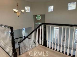 stairs featuring a high ceiling and a chandelier