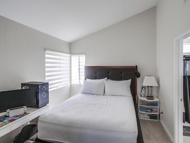 bedroom featuring lofted ceiling and carpet