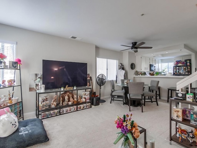 living room featuring light carpet and ceiling fan