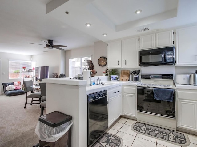 kitchen featuring white cabinetry, light tile patterned floors, a tray ceiling, kitchen peninsula, and black appliances