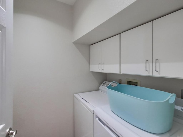 clothes washing area featuring cabinet space and washing machine and clothes dryer