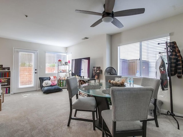 dining area featuring light carpet, baseboards, visible vents, and a ceiling fan