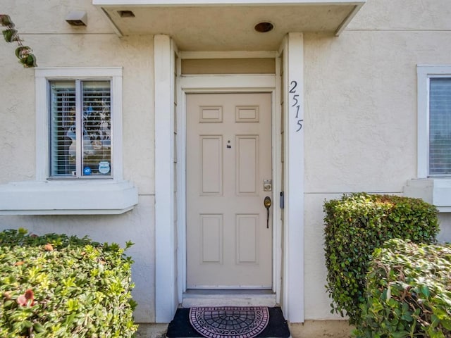 entrance to property featuring stucco siding