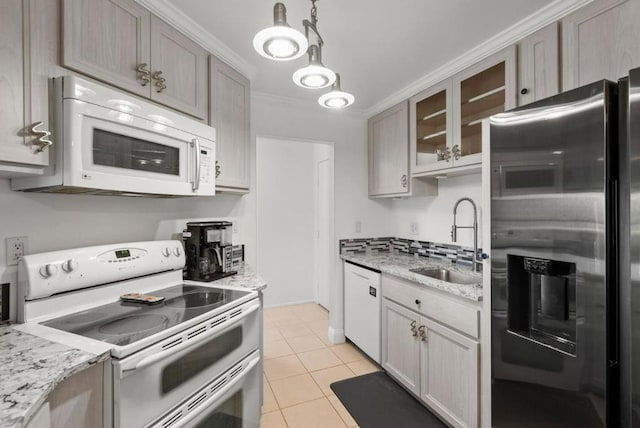 kitchen featuring sink, light tile patterned floors, light stone counters, crown molding, and white appliances