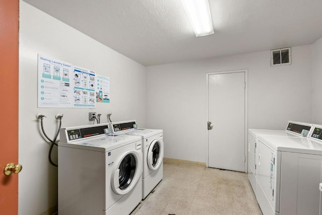 washroom featuring washer and dryer and a textured ceiling