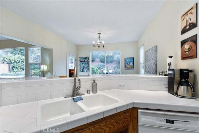 kitchen featuring plenty of natural light, tile countertops, dishwasher, and sink