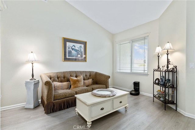 living room featuring light hardwood / wood-style floors and vaulted ceiling