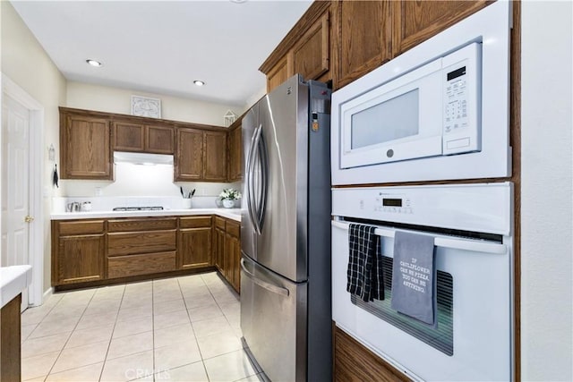 kitchen with light tile patterned floors and white appliances