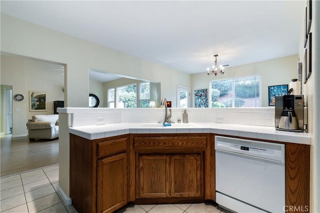 kitchen featuring sink, a wealth of natural light, tile countertops, and dishwasher