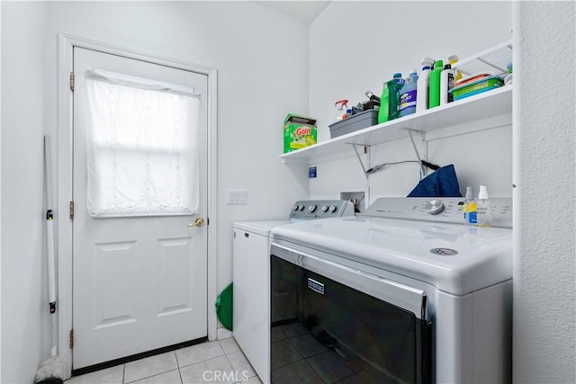 clothes washing area featuring washing machine and dryer and light tile patterned floors