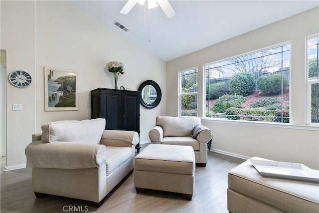 living room with hardwood / wood-style flooring, ceiling fan, a healthy amount of sunlight, and high vaulted ceiling