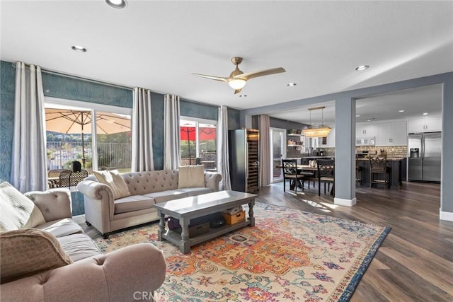 living room featuring recessed lighting, baseboards, dark wood-type flooring, and a ceiling fan