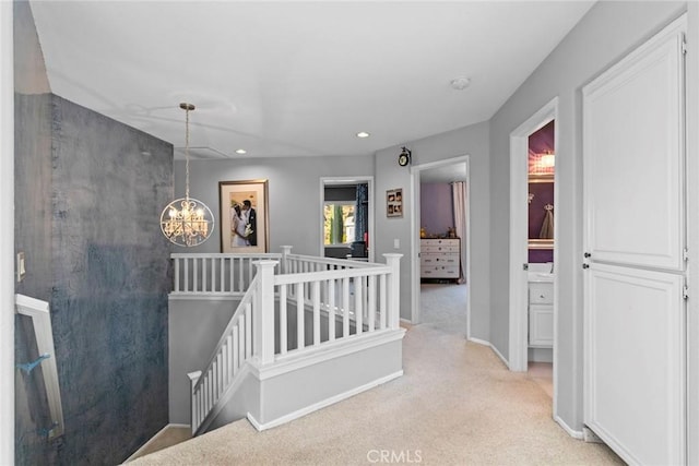 hall featuring baseboards, an upstairs landing, light carpet, recessed lighting, and an inviting chandelier