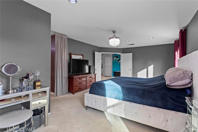 bedroom featuring light colored carpet, visible vents, and a closet