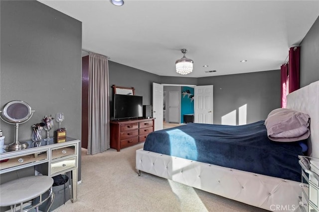 bedroom with visible vents, a closet, and light carpet