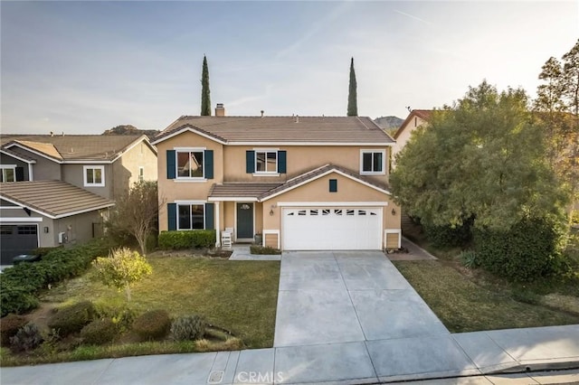 view of property featuring a garage and a front lawn