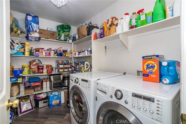 clothes washing area featuring wood finished floors, laundry area, and washing machine and clothes dryer