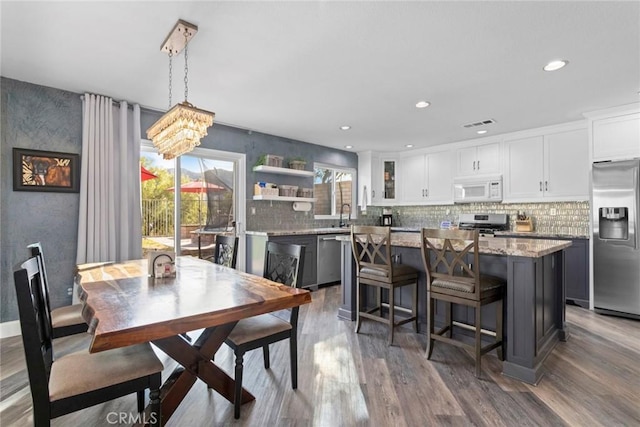 dining area with recessed lighting, wood finished floors, and visible vents