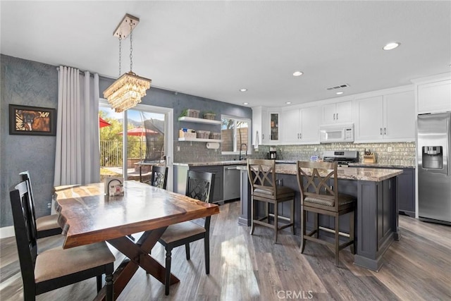 dining area with recessed lighting, a notable chandelier, wood finished floors, and visible vents