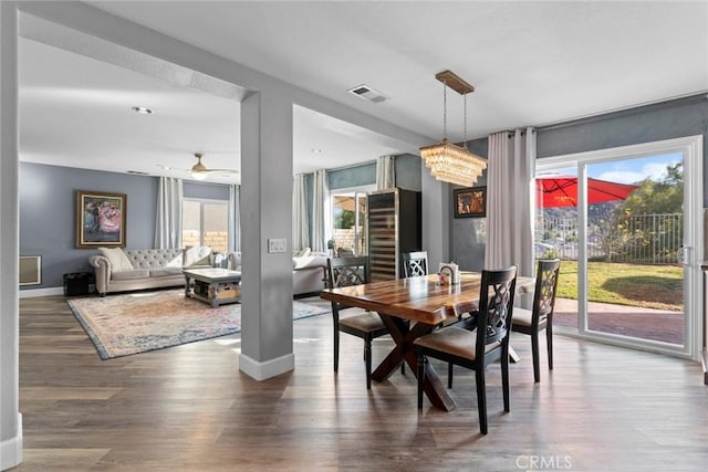 dining area with a wealth of natural light, visible vents, baseboards, and wood finished floors