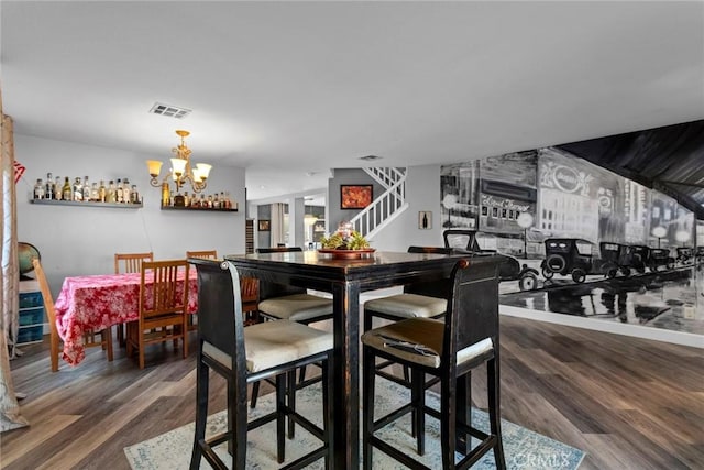 dining space with stairway, visible vents, and wood finished floors