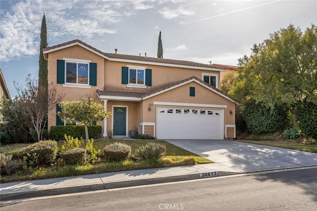 view of front of home featuring concrete driveway, a tiled roof, a garage, and stucco siding