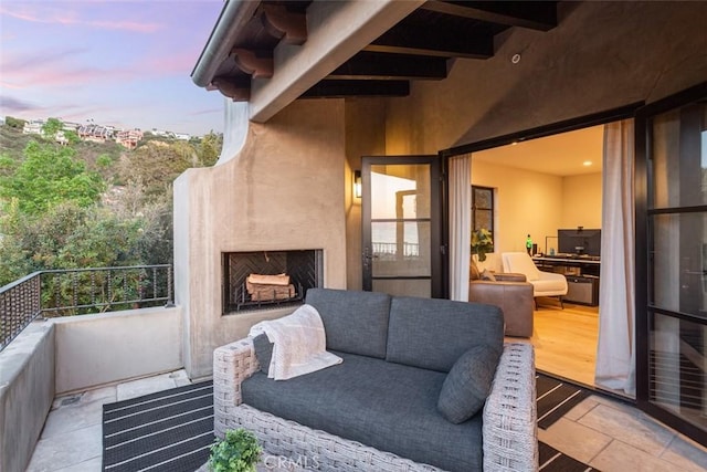 balcony at dusk with exterior fireplace