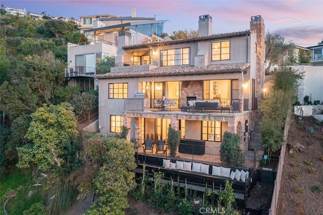 back house at dusk with a balcony