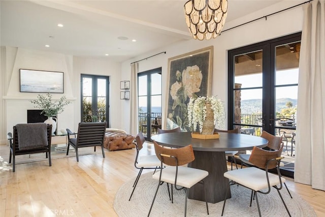 dining room featuring french doors, a chandelier, a mountain view, and light hardwood / wood-style floors