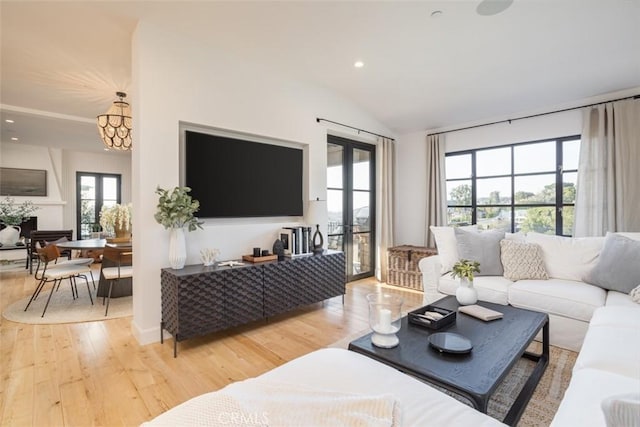 living room featuring french doors, wood-type flooring, and vaulted ceiling