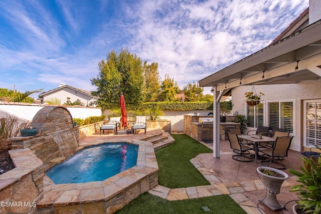 view of pool featuring pool water feature, area for grilling, and a patio area