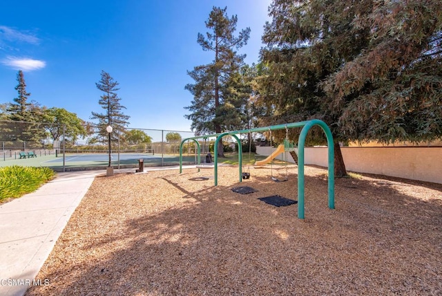 view of jungle gym featuring tennis court