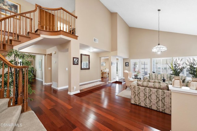 living room with an inviting chandelier, dark hardwood / wood-style flooring, and high vaulted ceiling