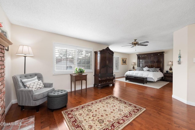 bedroom with dark wood-type flooring, ceiling fan, and a textured ceiling